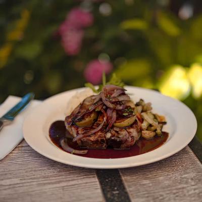 Steak topped with sautéed onions and gravy, served with sides.