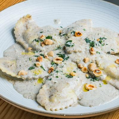 Ravioli smothered in black truffle cream sauce.