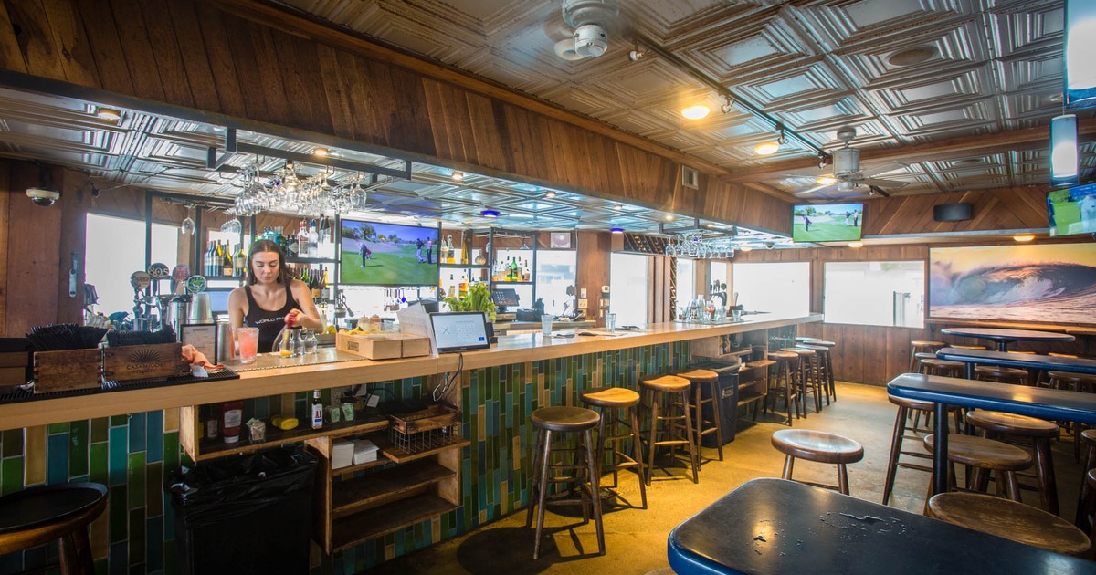 Interior, bar and seating area with an employee behind the bar counter
