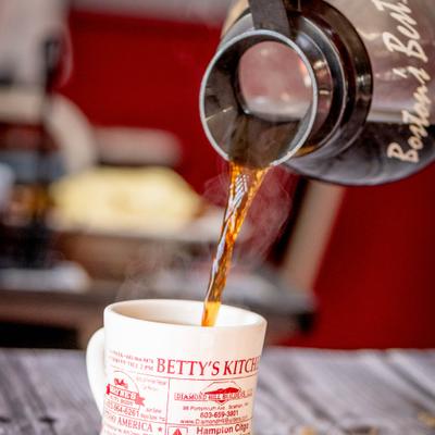 Coffee being poured into a mug from a carafe.