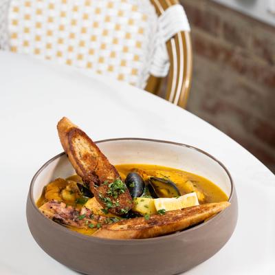 Sea food stew with toasted sourdough bread, served on the table.