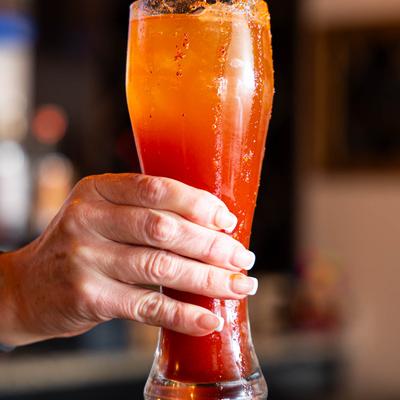 A hand holding a michelada.