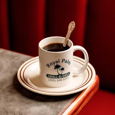 White mug filled with coffee on a matching saucer.
