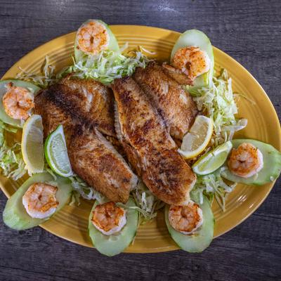 Grilled tilapia fillets and seasoned shrimp with lettuce and cucumbers.
