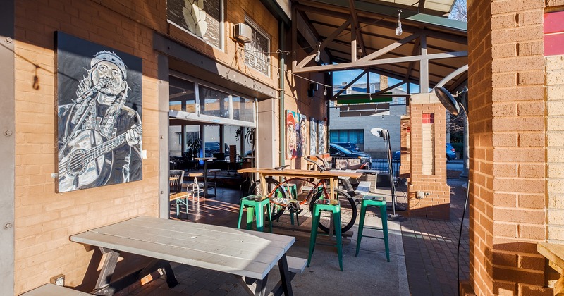 Covered patio with tables, stools and bench seating