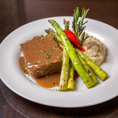 Braised short ribs, smothered in sauce, with asparagus, and mashed potatoes.