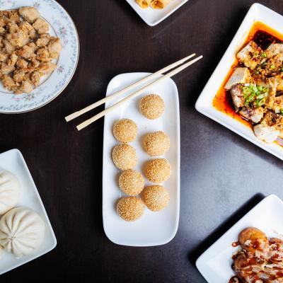 Sesame balls served with other Asian dishes on a table.