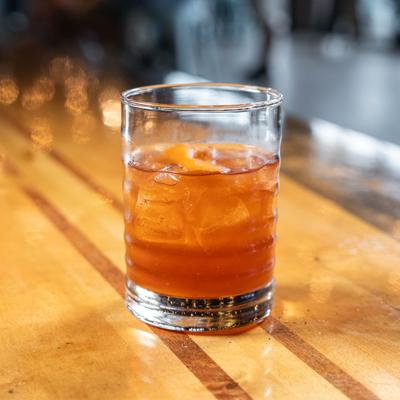 Old Fashioned cocktail with orange peel garnish.