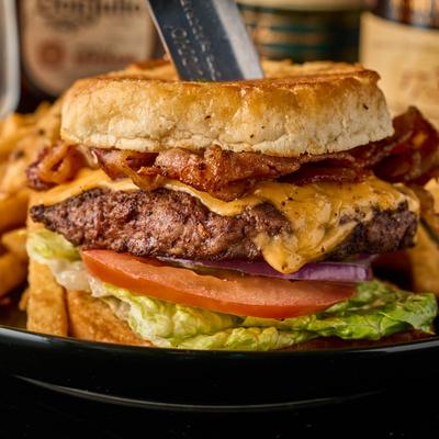Bacon cheeseburger with lettuce, tomato, and red onion.