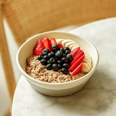 Oatmeal bowl topped with berries and banana slices.