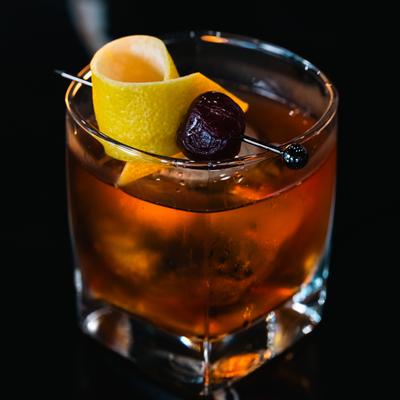 Fallen Samurai cocktail garnished with a lemon peel and a cherry.