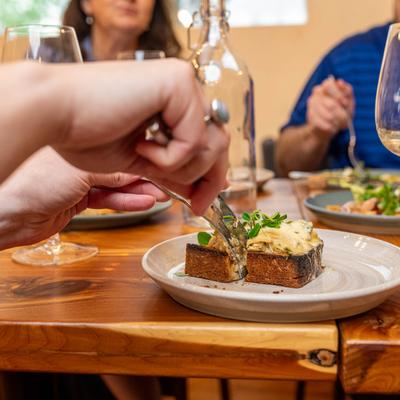 Hands cutting a meal with a knife and fork.