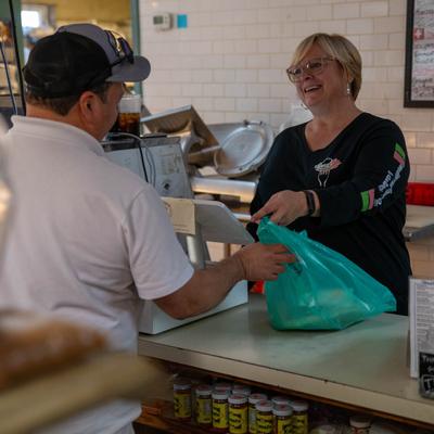 An employee handing a bag to a customer at a counter.