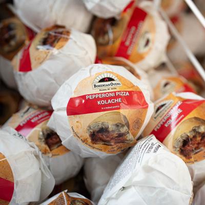 Wrapped Pepperoni Pizza Kolaches piled in a plastic container.