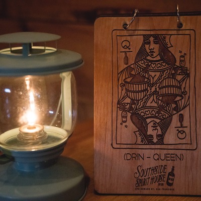 Branded wooden queen playing card with a  candle lantern.