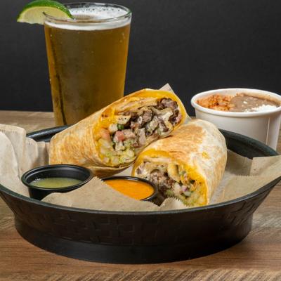 California Burrito with dipping sauces, rice and refried beans, accompanied with a draft beer.
