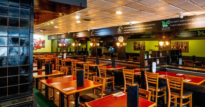 Interior - wooden chairs, red-topped tables and green walls adorned with food-themed artwork.
