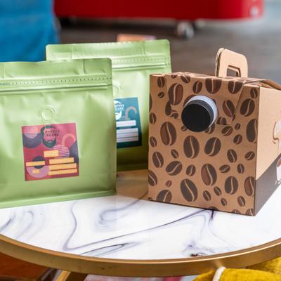 Bags of Pumphrey and Beard medium roast Arabica coffee on a small round table.