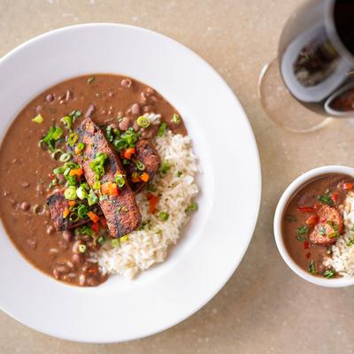 Red Beans & Rice Appetizer with gumbo and a glass of red wine on the side