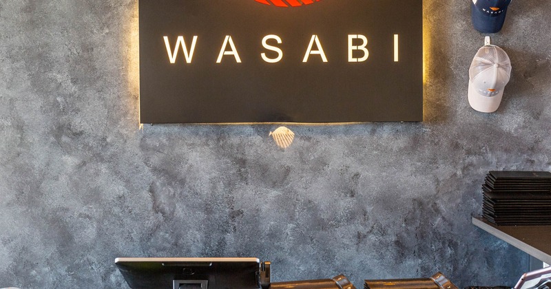 Front desk featuring a board with the restaurant's logo