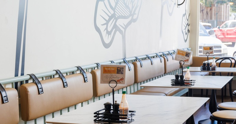 Interior, banquette seating and tables by a wall