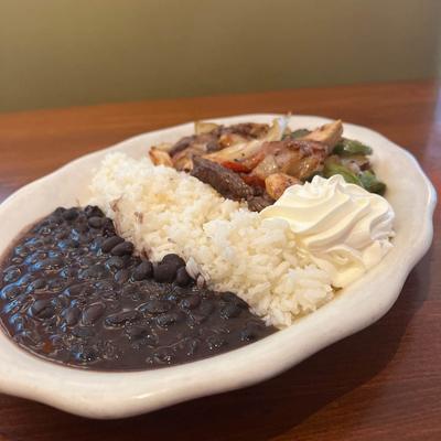Chicken, steak, and shrimp, with grilled peppers, onions, rice, beans, and sour cream.