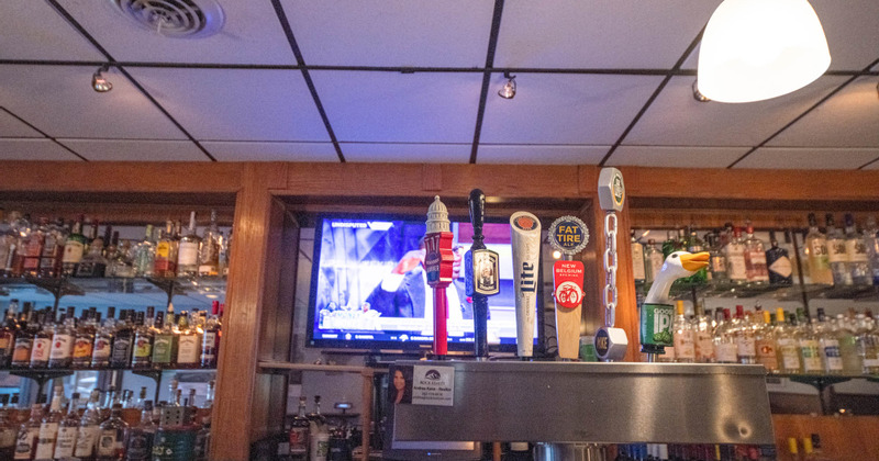 Bar area, lots of bottles, beer taps, TV screen