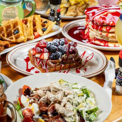 Table filled with breakfast dishes and salad.