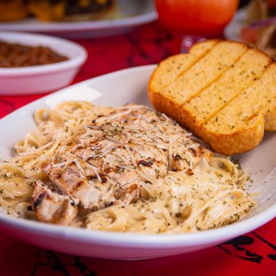 Blackened Chicken Feta Alfredo served with garlic bread on the side.