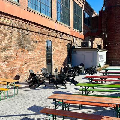 Exterior, seating area, wooden beer garden tables and lounging chairs.
