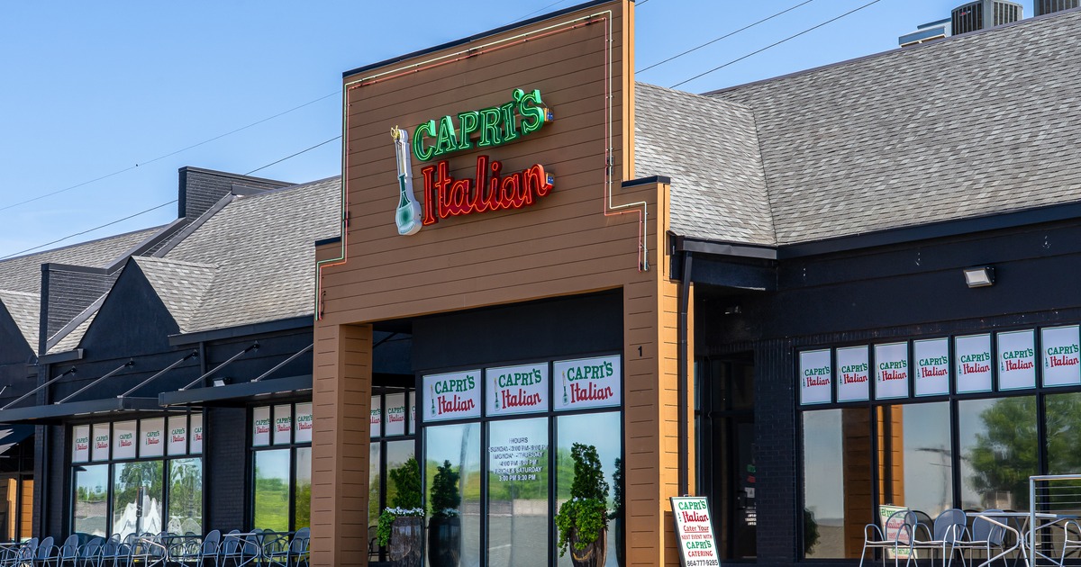 Exterior, front view to restaurant, parking lot, sign above entrance