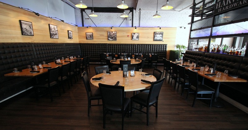 Interior, set tables with bar chairs and dining booths by a wall