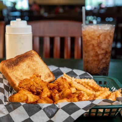 Fried chicken basket with toast and fries, accompanied with a cup of soda drink.