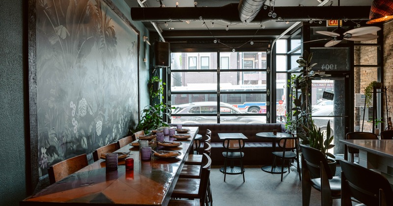 Interior of a modern cafe featuring a long wooden table set