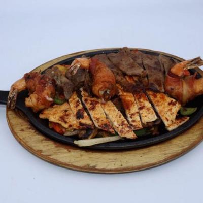 Fajitas trio with chicken, steak and bacon wrapped shrimp.