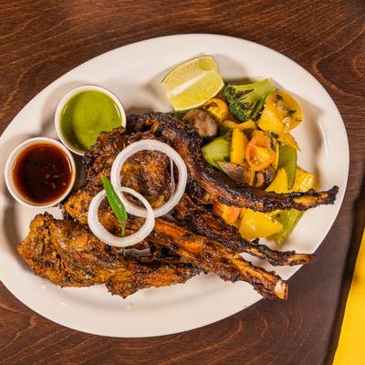 Grilled lamb chops with roasted vegetables and dipping sauces.