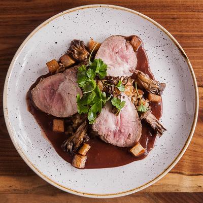 Tenderloin steak served with a rich sauce, mushrooms, and diced root vegetables.