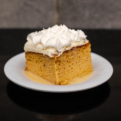 Tres leches cake topped with whipped cream.