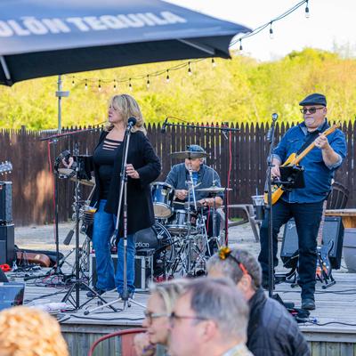 A band performs on a patio stage.