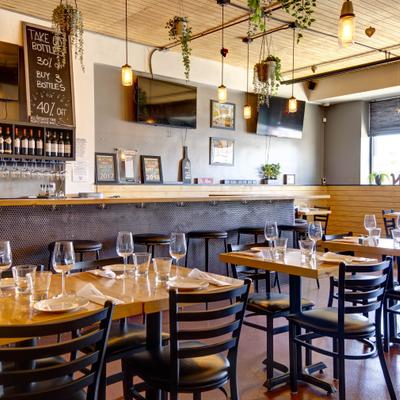 Bar seating area with tables set with empty wine glasses.