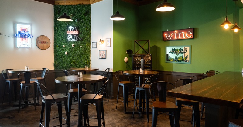 Interior seating area with high round tables and metal stools