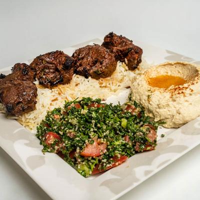 Filet Mignon, on a bed of rice, with hummus, and salad.