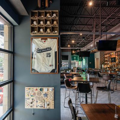 Interior, tables, chairs, bar, framed jersey on the wall.