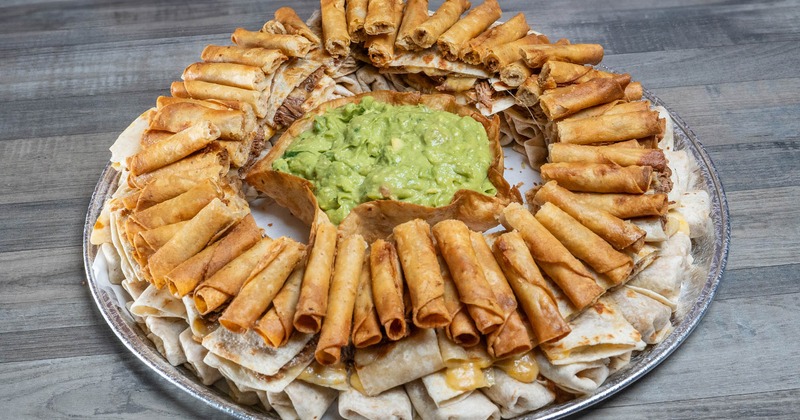 Mini taquitos, burritos, quesadillas, and guacamole on party tray