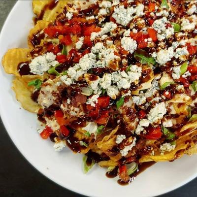 Bacon and blue cheese bay chips topped with balsamic glaze, close-up.