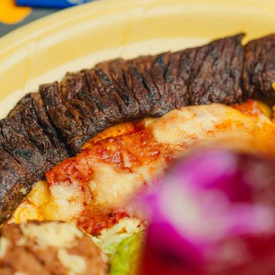 Grilled steak and enchilada, close-up.