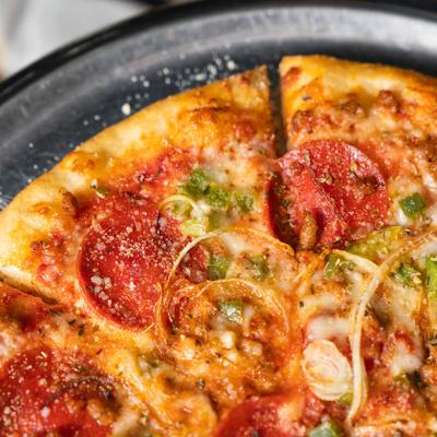 Pepperoni and sausage pizza with green peppers and onions.