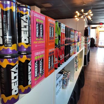 Interior, canned drinks lined up on a shelf.