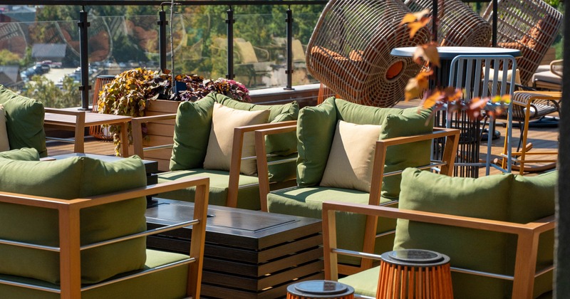 Outdoor patio with wooden deck, green cushioned chairs