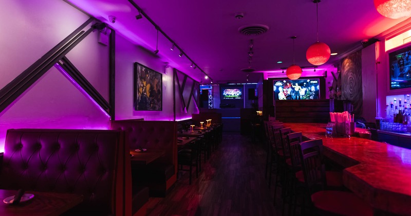 Interior, dining area, row of seating booths on the left, marble top bar with stools on the right